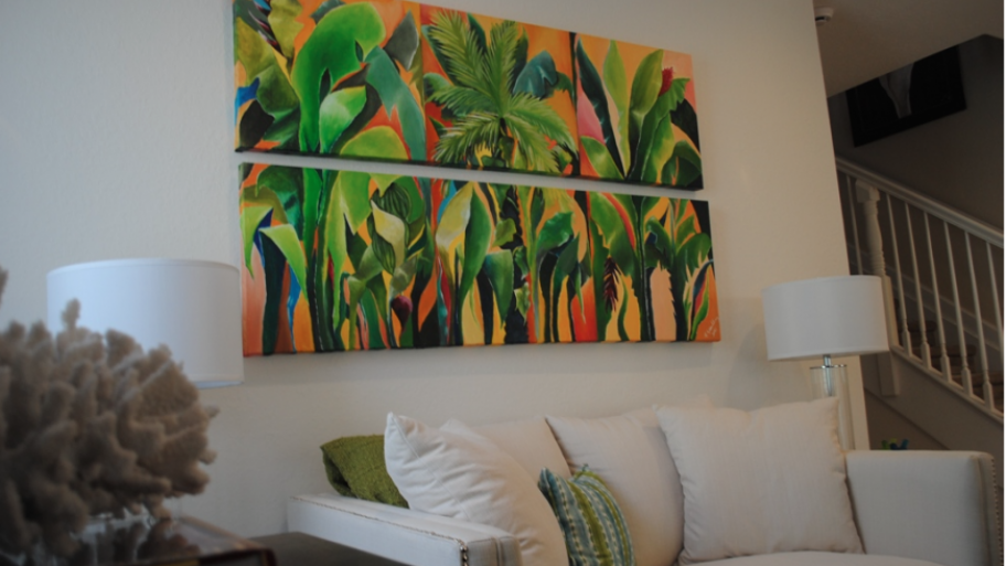 Home interior with artwork, lamps, sofa and decorative objects.